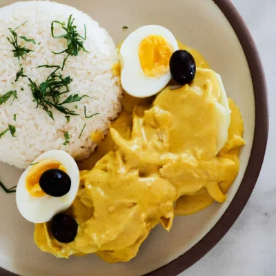 Arroz con pollo en salsa amarilla, huevo y aceitunas